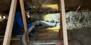 Mesa attic insulation removal in progress to prepare for new blown-in fiberglass insulation.