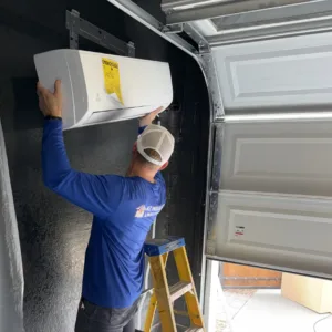 Professional installer mounting a ductless mini split system in a Mesa, Arizona garage to improve temperature control and efficiency.