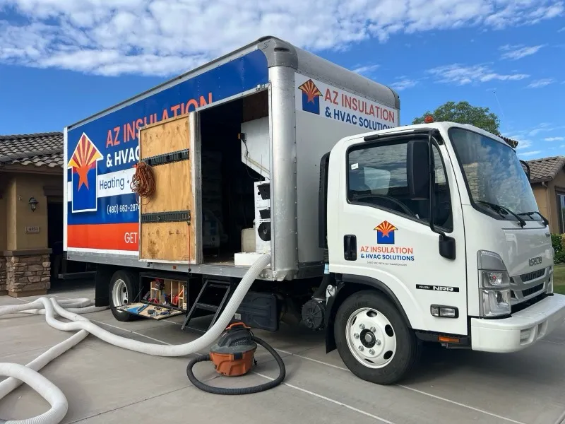 AZ Insulation truck-mounted blower filling a Chandler garage with insulation