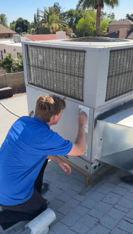 AZ Insulation technician inspecting and cleaning a rooftop packaged HVAC unit in Gilbert