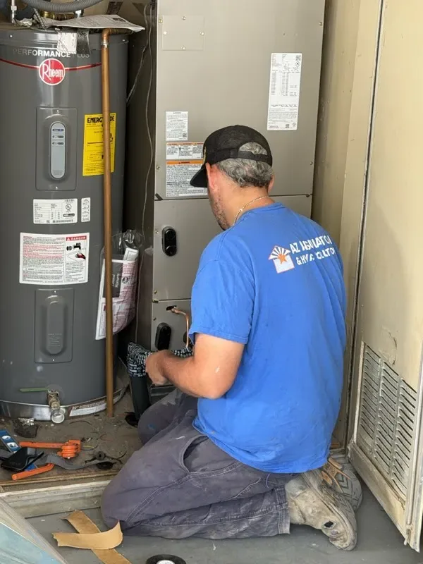 AZ Insulation technician tuning up a split-system heat pump air handler in Phoenix