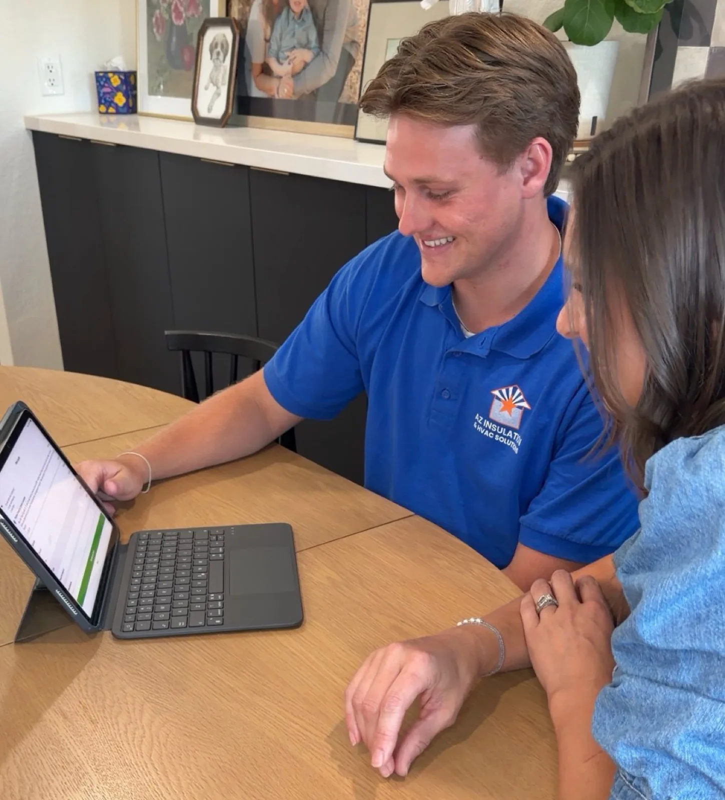 AZ Insulation specialist reviewing SRP rebate savings with a homeowner on a tablet