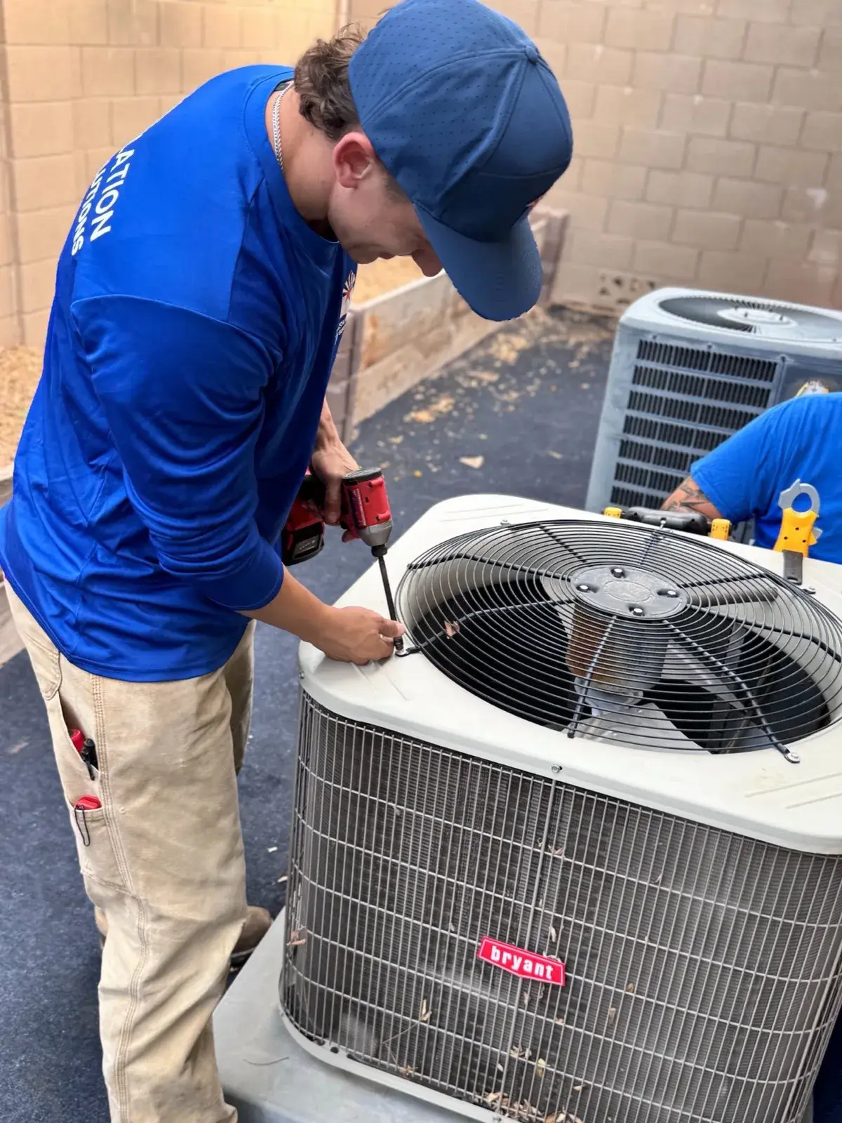 An AZ Insulation technician checking an air conditioner condenser at an Arizona home in the fall.
